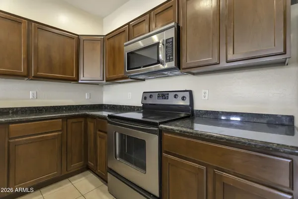 a kitchen with stainless steel appliances granite countertop a sink stove and microwave
