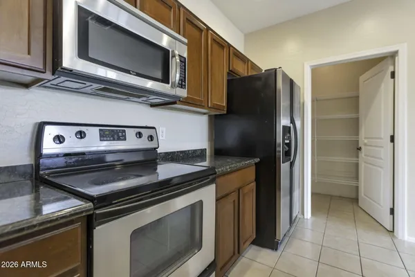 a kitchen with stainless steel appliances granite countertop a stove microwave and refrigerator