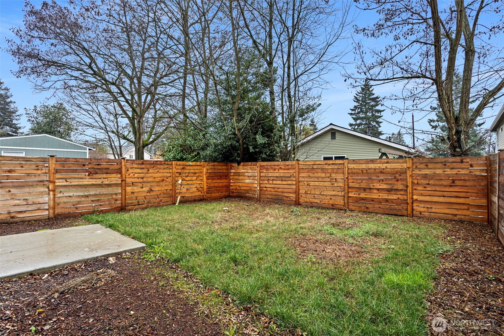 a view of a yard with wooden fence