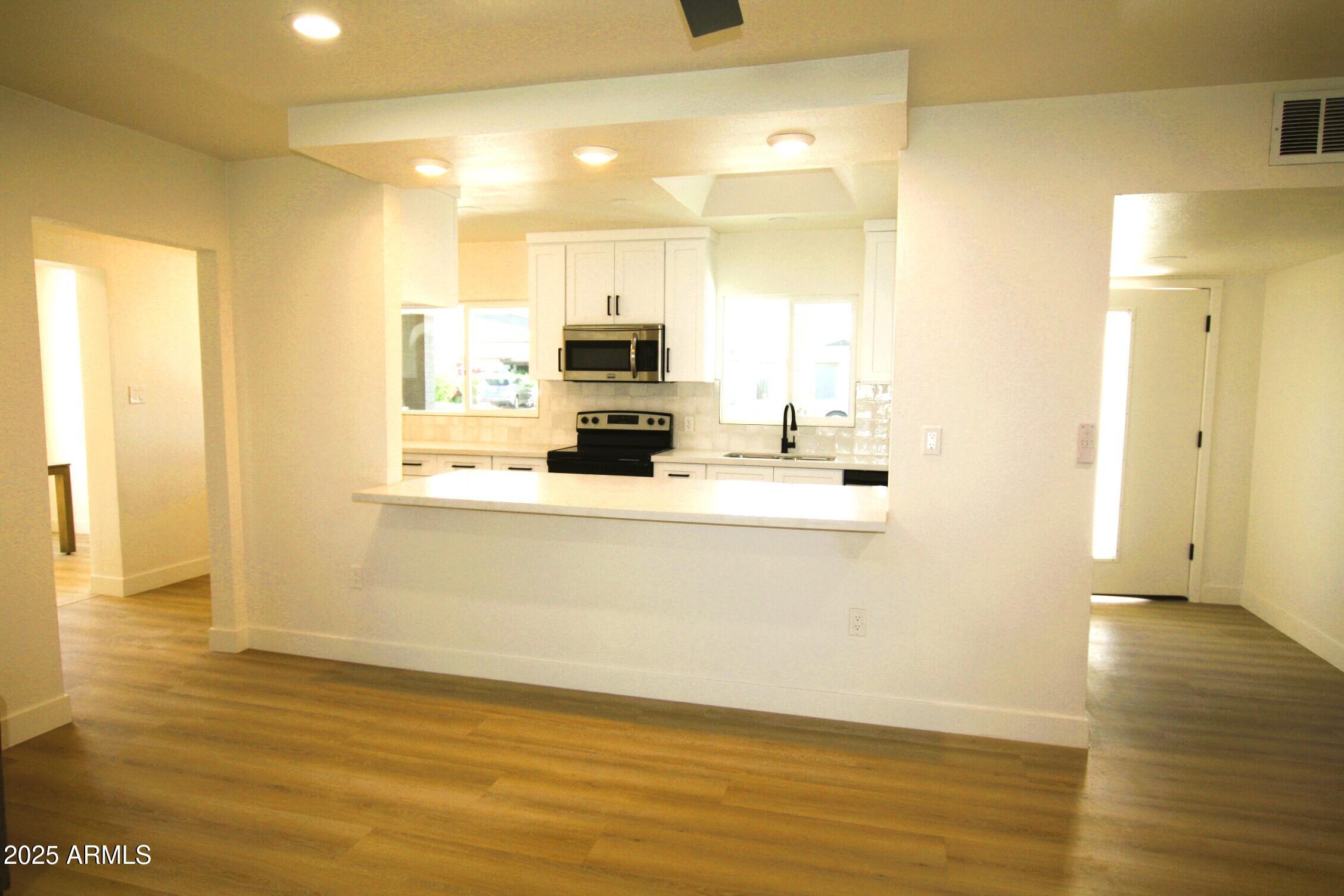 443 North Sycamore Mesa, AZ 85201 - Photo 11 of 33 a view of a kitchen with kitchen island a sink wooden floor and a counter top space