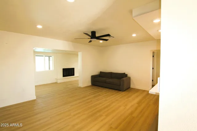 a view of a livingroom with a ceiling fan and wooden floor