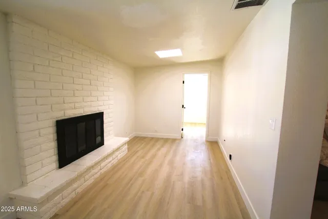 an empty room with a window and a fan