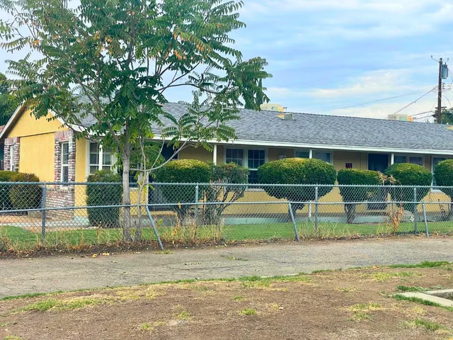 a view of house with backyard and outdoor seating