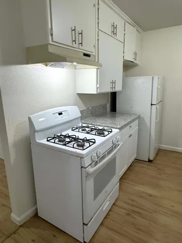 a white stove top oven sitting inside of a kitchen