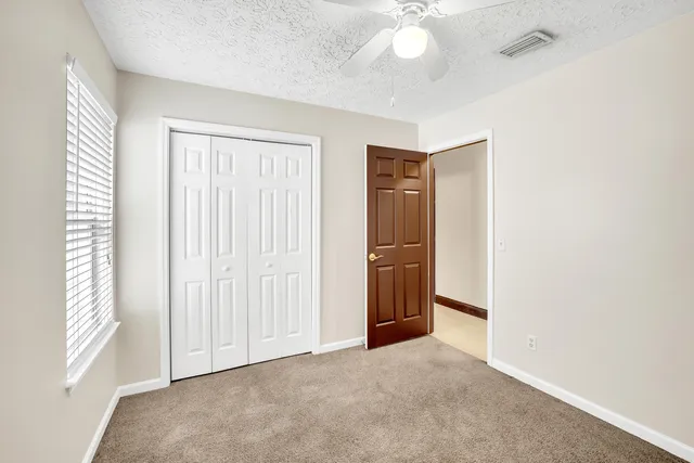 an empty room with windows and cabinet