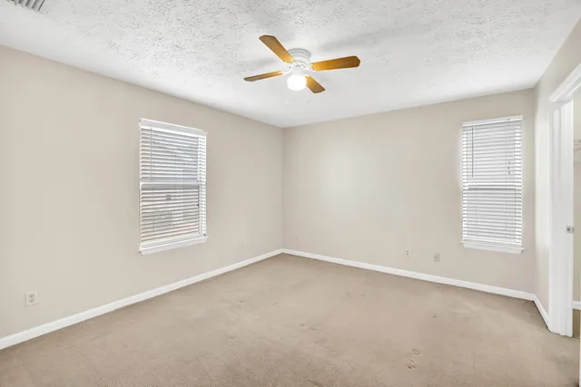 an empty room with closet and windows