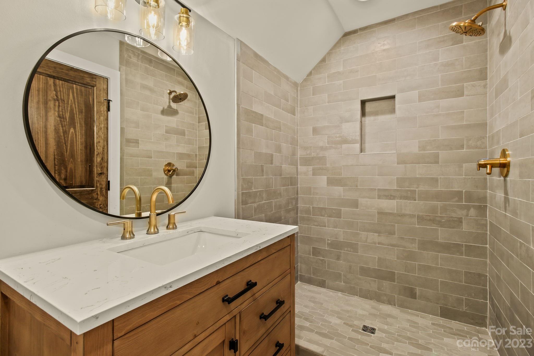 1736 Twin Rivers Drive Boone, NC 28607 - Photo 29 of 48 a bathroom with a sink a mirror a vanity and a shower