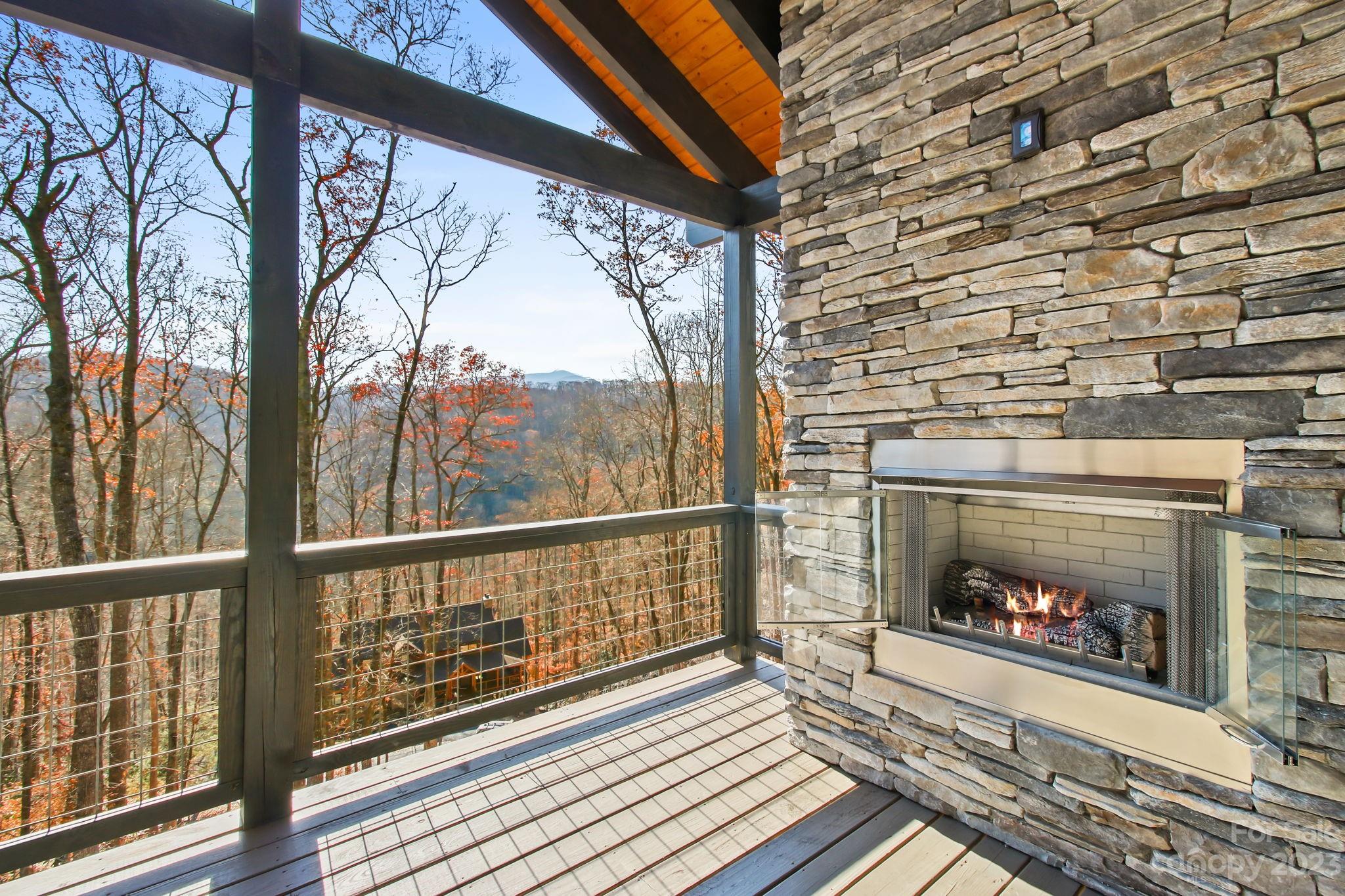 1736 Twin Rivers Drive Boone, NC 28607 - Photo 3 of 48 a living room with a fireplace and a floor to ceiling window