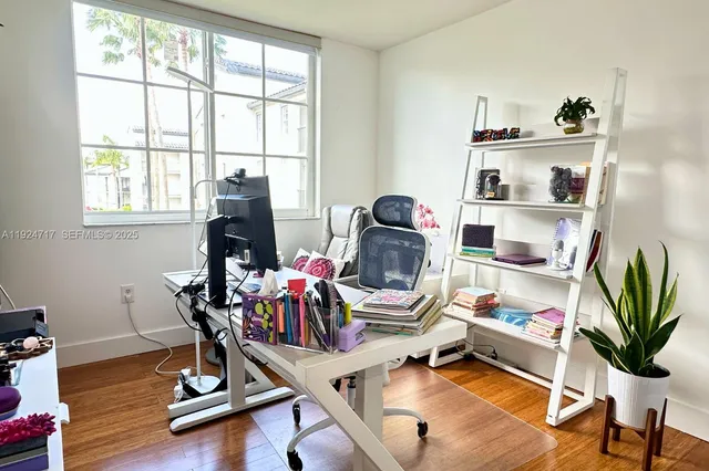 a view of a workspace with furniture and a window