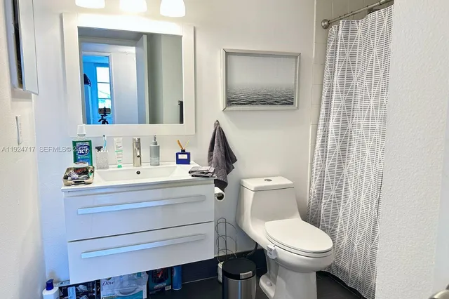a bathroom with a sink toilet and mirror