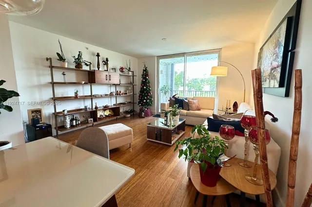 a living room with furniture a rug and a floor to ceiling window