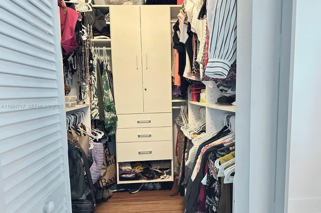 a view of walk in closet with clothes and shoes
