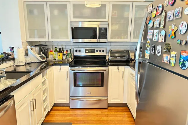 a kitchen with stainless steel appliances a stove a microwave and a refrigerator