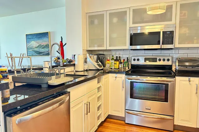 a kitchen with stainless steel appliances a stove and a microwave