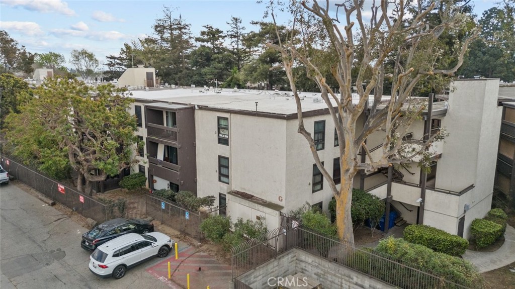 7740 Redlands Street, Unit G1097 Playa del Rey, CA 90293 - Photo 2 of 37 a view of a white house next to a yard with potted plants