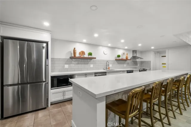 a kitchen with stainless steel appliances a refrigerator and a stove top oven