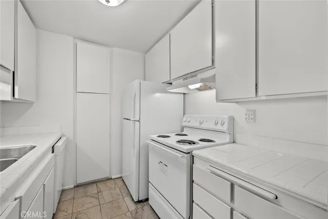a kitchen with white cabinets and white appliances
