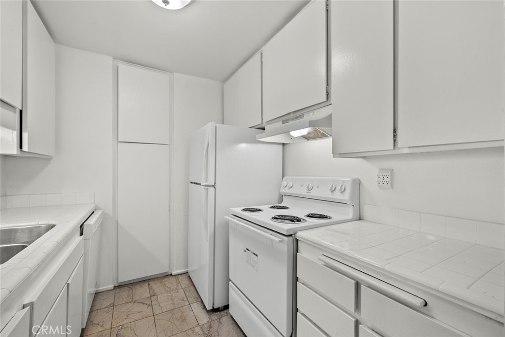7740 Redlands Street, Unit G1097 Playa del Rey, CA 90293 - Photo 10 of 37 a kitchen with white cabinets and white appliances