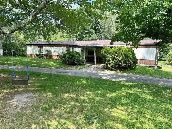 a view of a house with a yard and sitting area