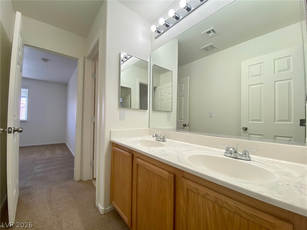 4033 Spring Line Street North Las Vegas, NV 89032 - Photo 20 of 30 This bathroom features a double vanity with ample counter space and a large mirror.