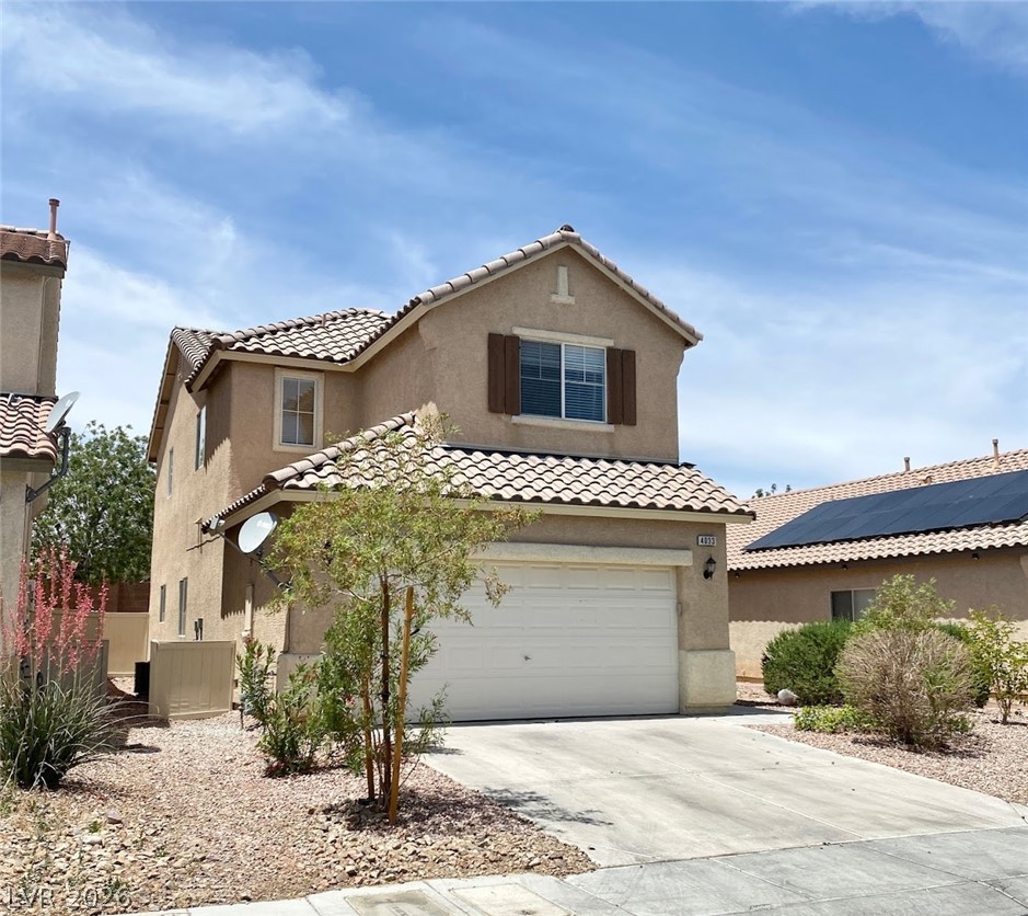4033 Spring Line Street North Las Vegas, NV 89032 - Photo 2 of 30 A classic two-story house with an attached garage under a vast sky.