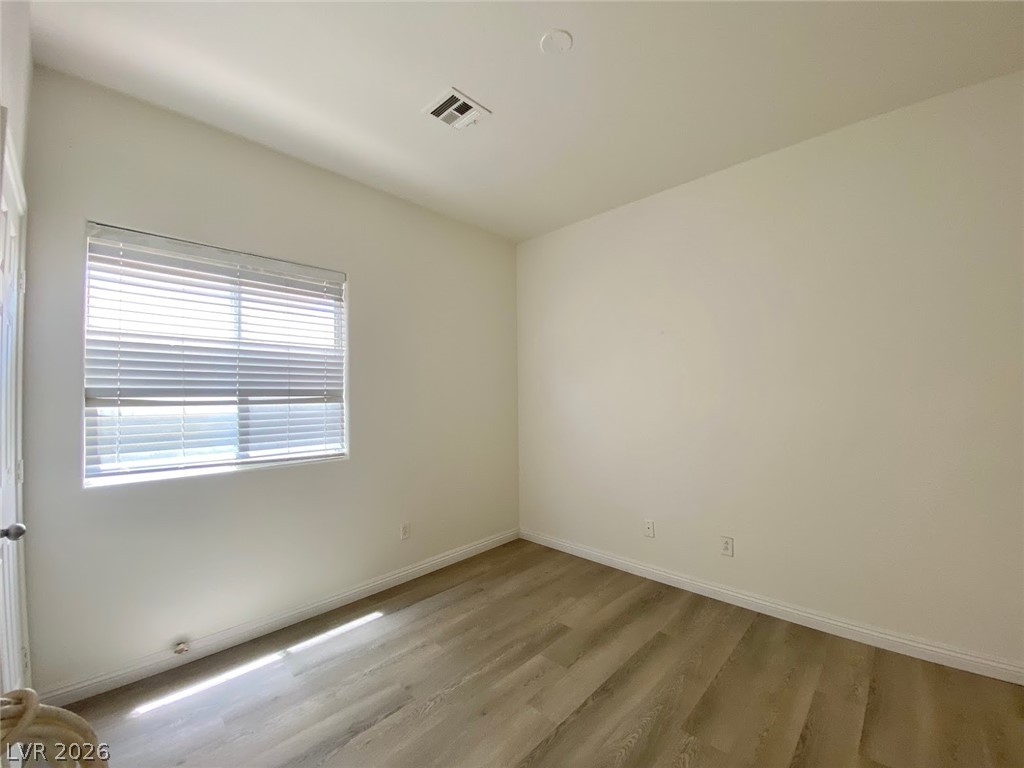 4033 Spring Line Street North Las Vegas, NV 89032 - Photo 26 of 30 This bright room features durable laminate flooring and a large window, offering a versatile living space.