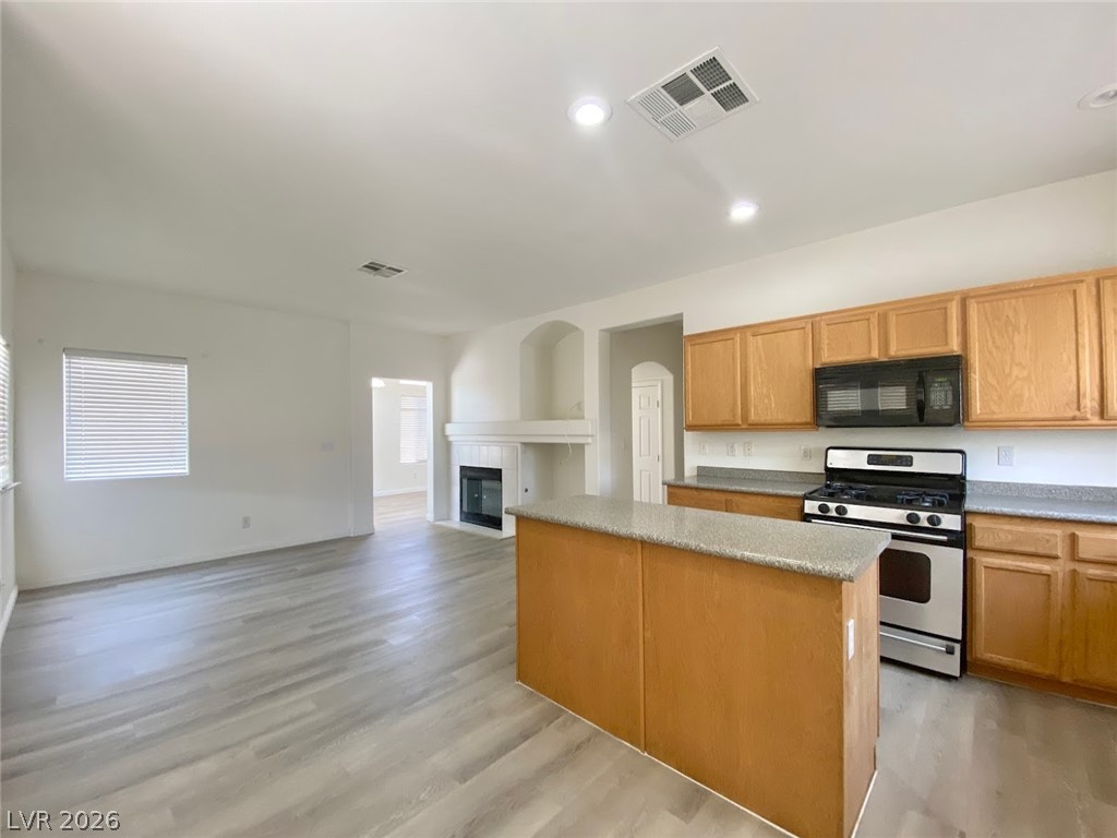 4033 Spring Line Street North Las Vegas, NV 89032 - Photo 6 of 30 Bright and airy open-concept living space with a kitchen island and fireplace.