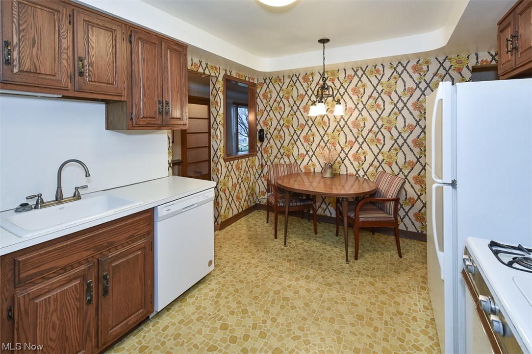 4026 Stonehaven Road Cleveland, OH 44121 - Photo 2 of 30 Kitchen featuring light tile floors, sink, white appliances, a notable chandelier, and decorative light fixtures