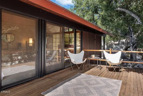 a balcony with wooden floor and outdoor seating