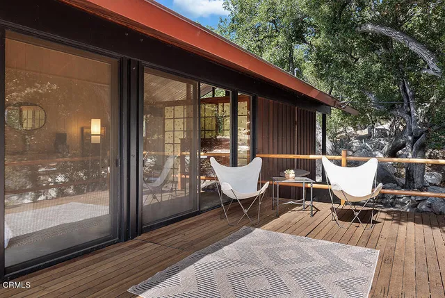 a balcony with wooden floor and outdoor seating