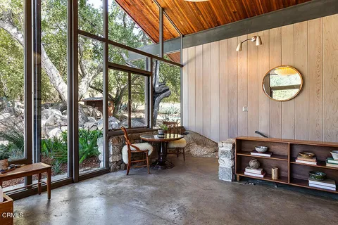 a living room with furniture and a floor to ceiling window