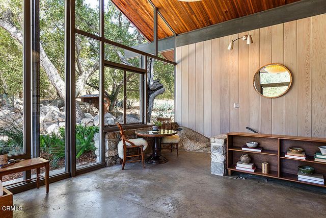 a living room with furniture and a floor to ceiling window