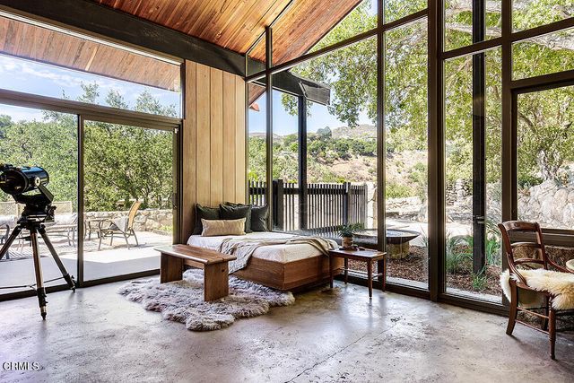 a bedroom with furniture and large windows