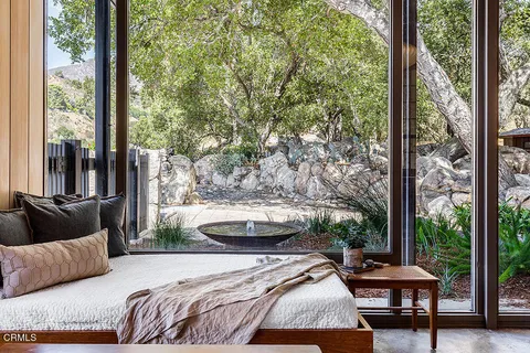 a bedroom with a bed and large windows