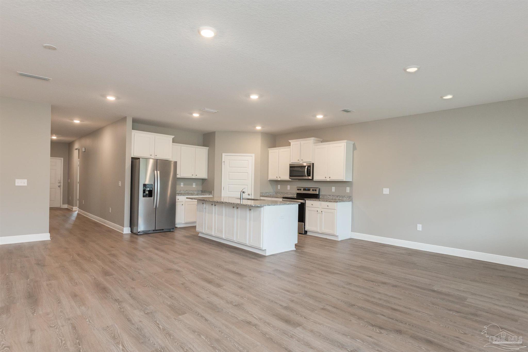 7882 Burnside Loop Pensacola, FL 32526 - Photo 12 of 28 a view of kitchen with stainless steel appliances refrigerator oven and white cabinets with wooden floor