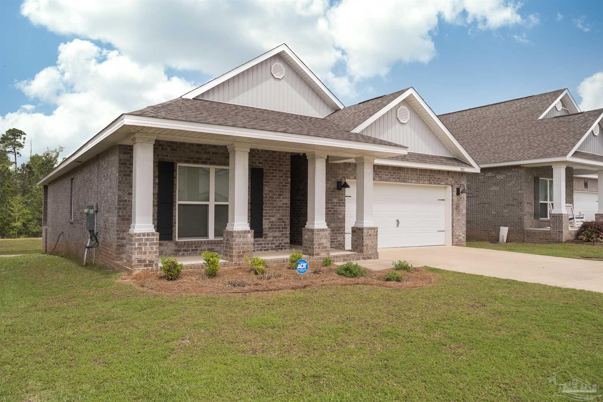 7882 Burnside Loop Pensacola, FL 32526 - Photo 3 of 28 a front view of a house with a yard outdoor seating and garage