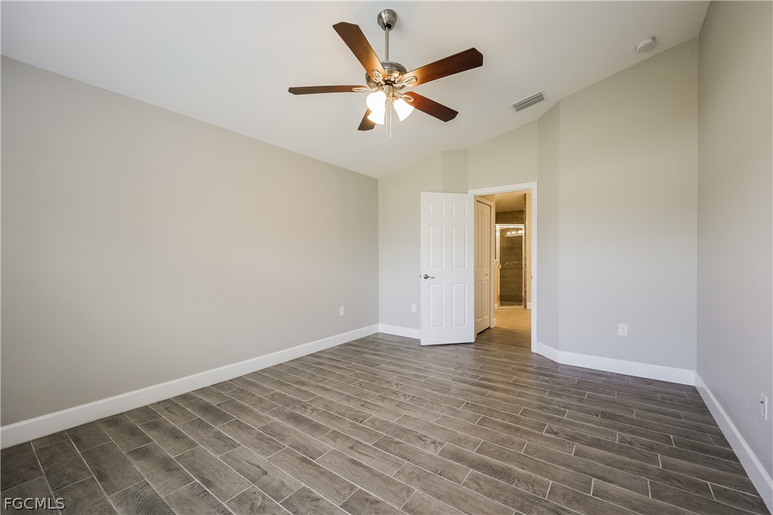 2900 7th Street West Lehigh Acres, FL 33971 - Photo 14 of 15 an empty room with wooden floor and ceiling fan