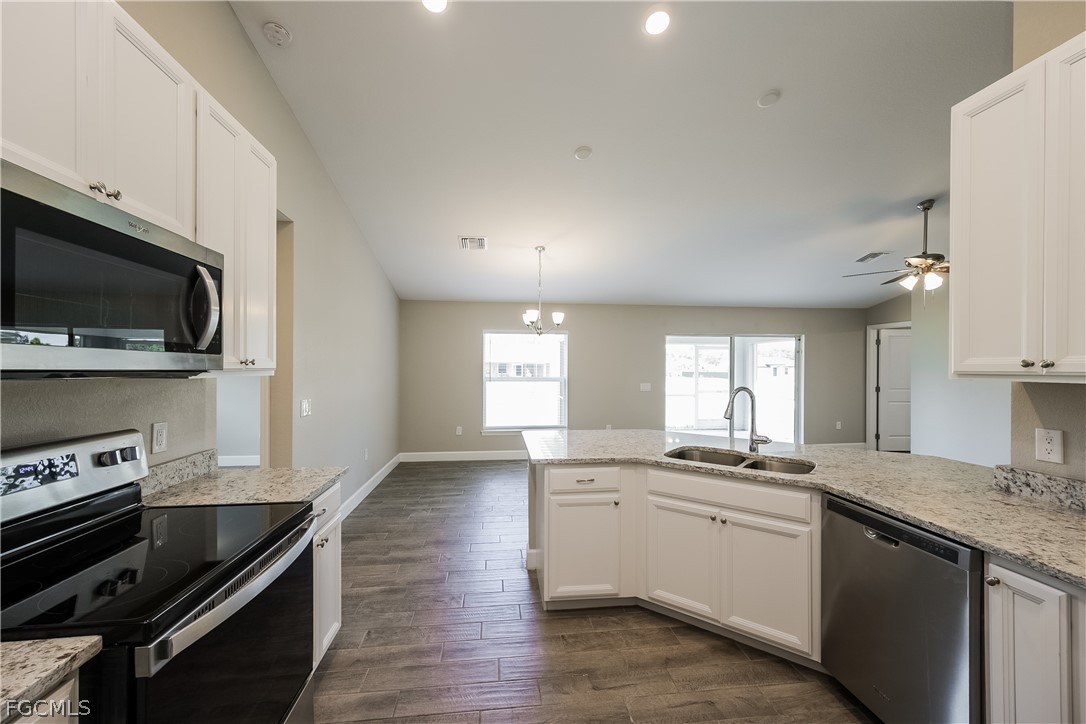 2900 7th Street West Lehigh Acres, FL 33971 - Photo 7 of 15 a kitchen with granite countertop a sink cabinets and stainless steel appliances