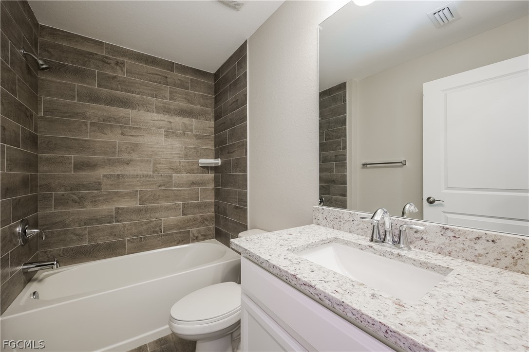 2900 7th Street West Lehigh Acres, FL 33971 - Photo 8 of 15 a bathroom with a granite countertop bathtub shower sink vanity and toilet