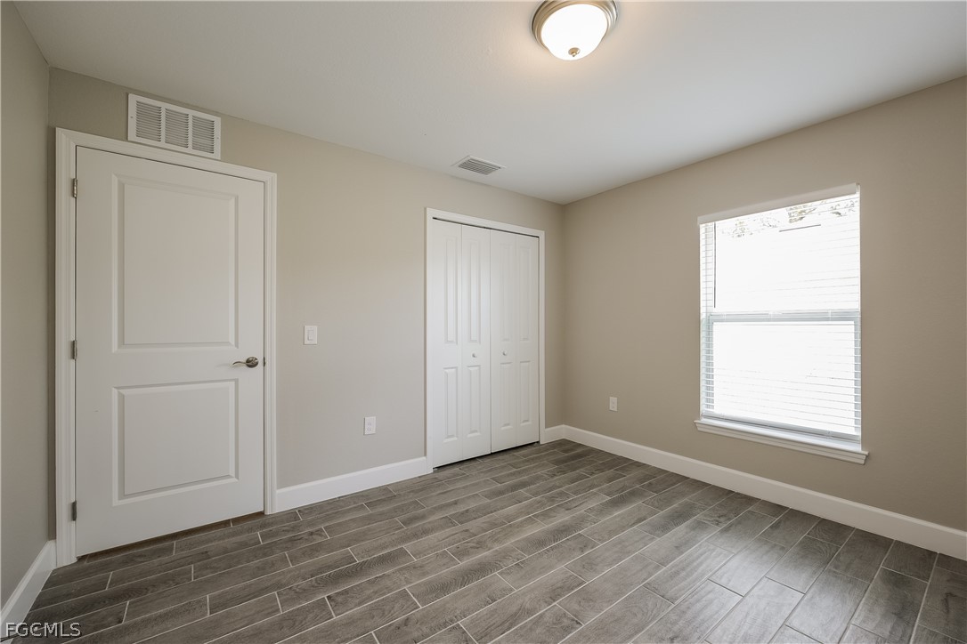 2900 7th Street West Lehigh Acres, FL 33971 - Photo 10 of 15 an empty room with wooden floor and windows