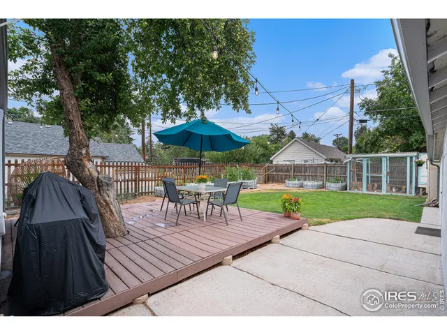 a view of backyard with outdoor seating and wooden fence
