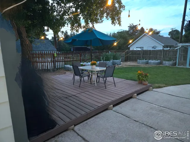 a view of a backyard with table and chairs under an umbrella