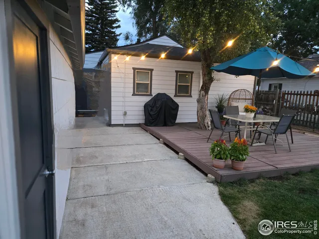 a view of a patio with a table and chairs under an umbrella
