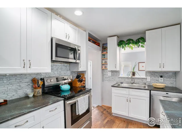 a kitchen with stainless steel appliances granite countertop a sink stove and cabinets