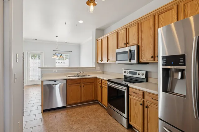 a kitchen with stainless steel appliances granite countertop a refrigerator stove microwave and sink