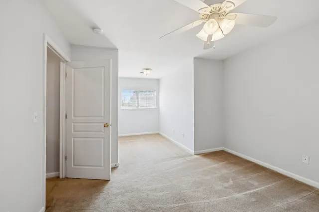 an empty room with chandelier fan