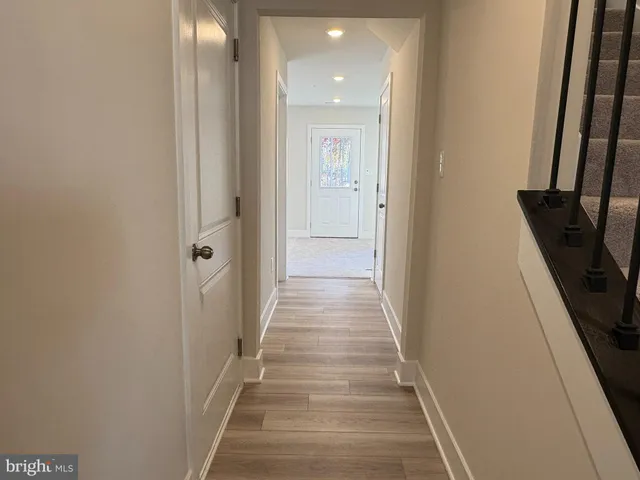 a view of a hallway with wooden floor and staircase