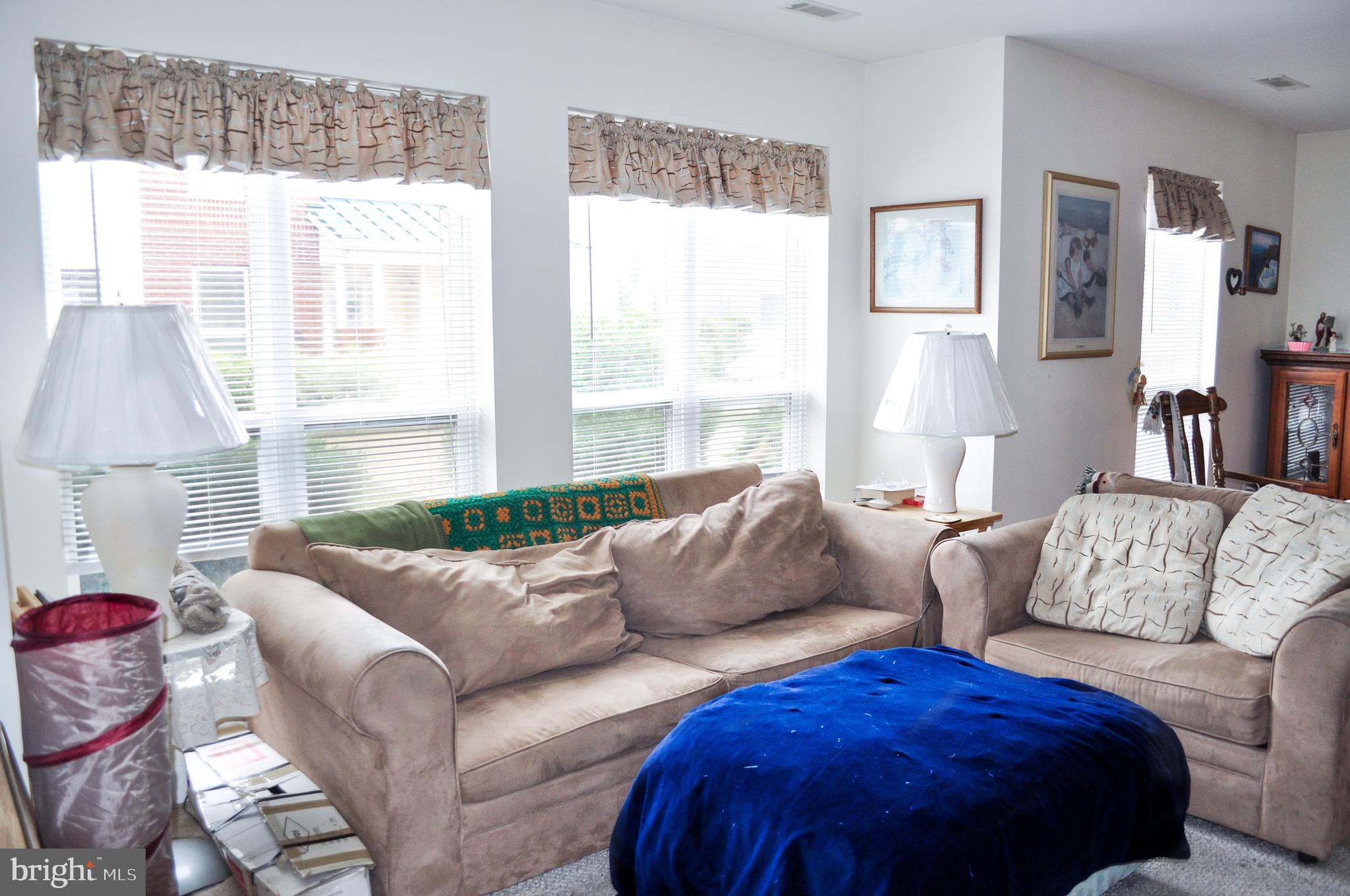 703 Canning House Row, Unit 902 Milton, DE 19968 - Photo 5 of 18 a living room with furniture and a large window