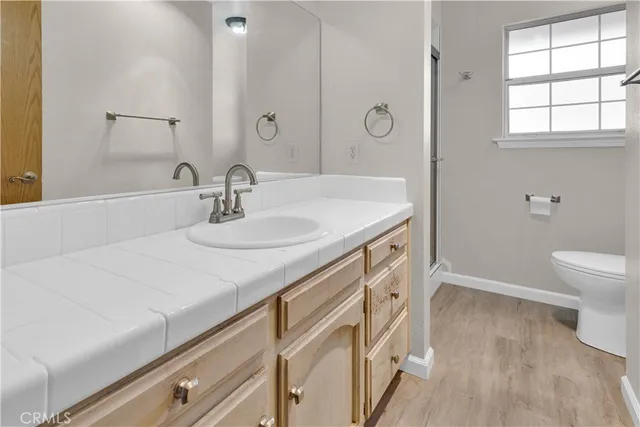 a view of an empty room with wooden floor fireplace and a window