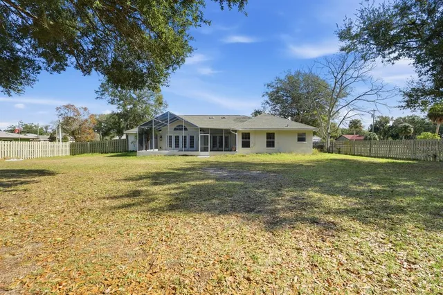 a view of a large house with a big yard and large trees